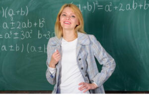 An image of a teacher with a blackboard at the background